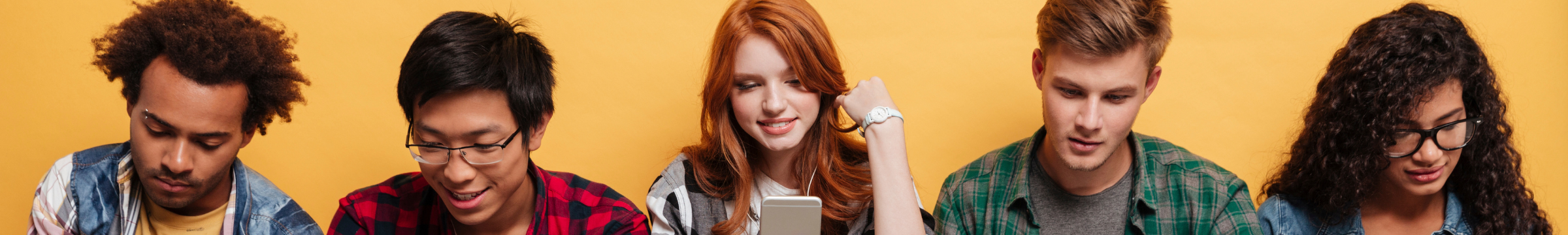 Ein Foto von 5 Jugendlichen ist zu sehen, die auf ihre Handys schauen.